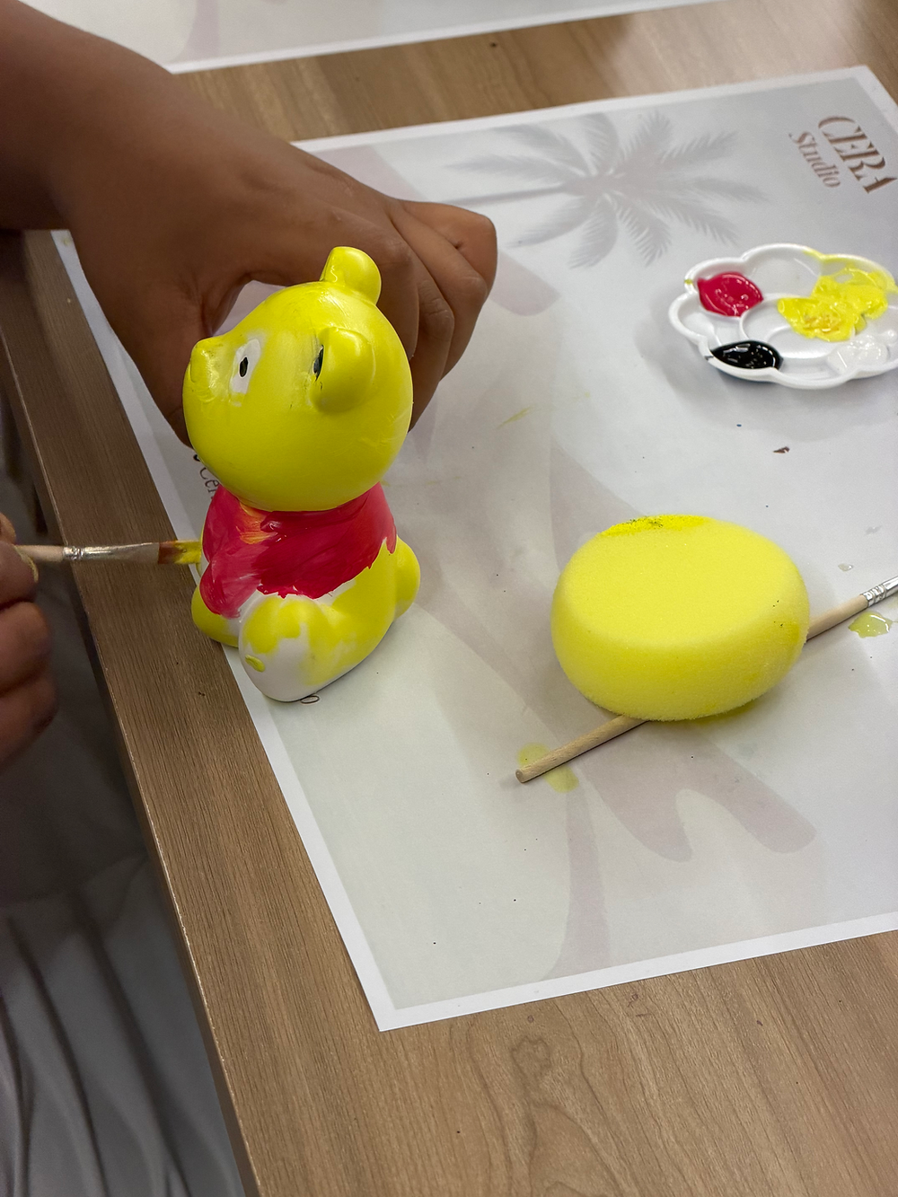 Child painting ceramic art at THE ART STUDIO THAT COMES TO YOU.