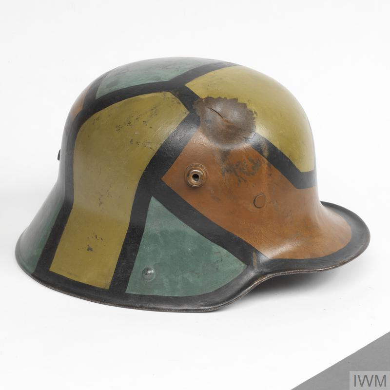WW1 German M1916 Stahlhelm with original camouflage paint in jagged green, tan, and rust-colored geometric pattern, Imperial War Museum