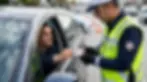 Trafik denetiminde sürücü belgesi kontrolü yapan görevli ile ehliyet kodlarının incelendiği profesyonel sahne