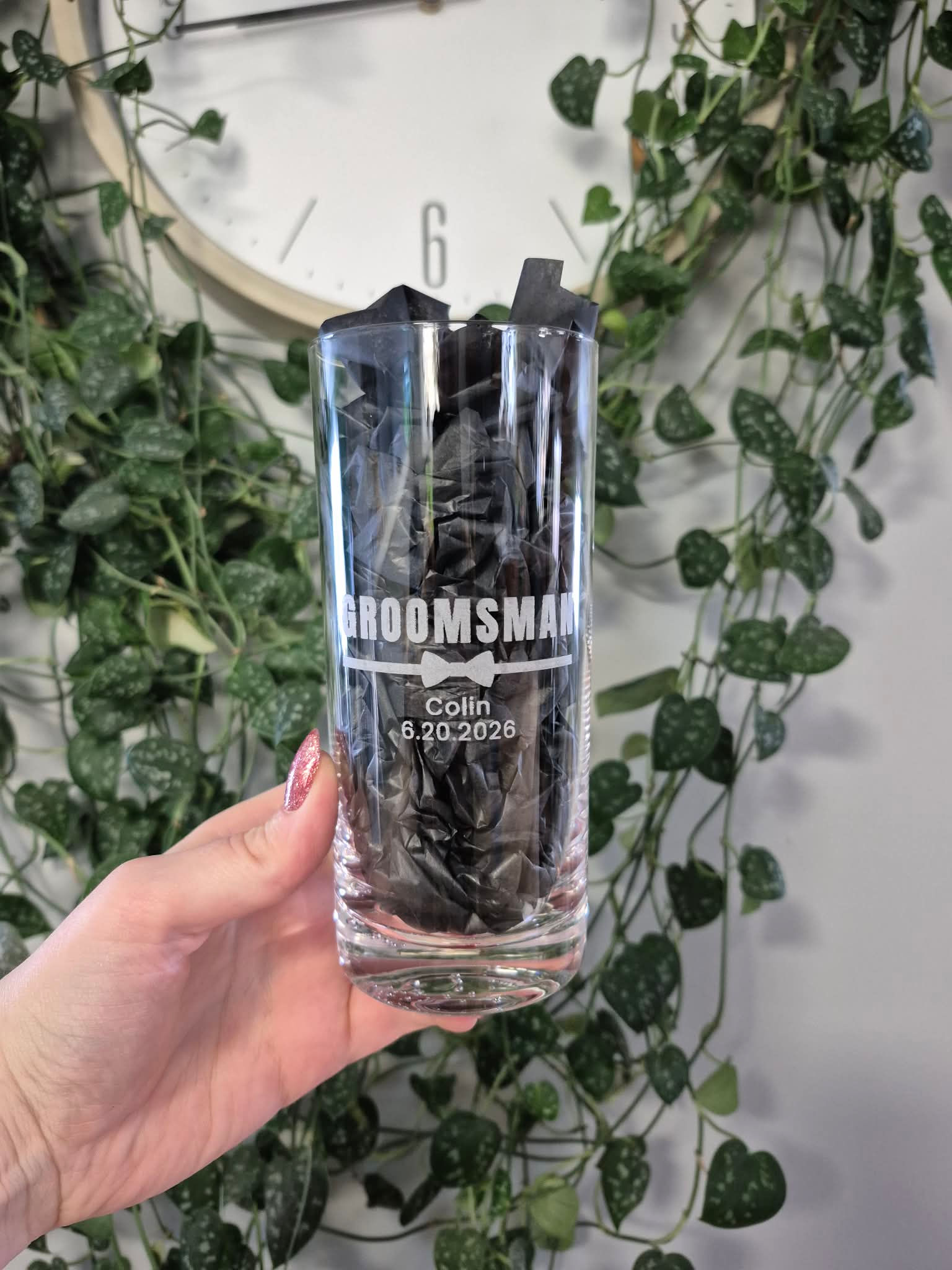 Hand holding 'GROOMSMAN' glass