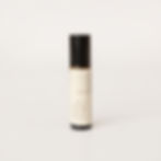 Small amber glass rollerball bottle with black lid and pale beige label