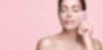 A woman holding a Gua Sha massage stone to her face