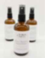 Three brown glass bottles of magnesium spray with spray top lids and white labels on white background.