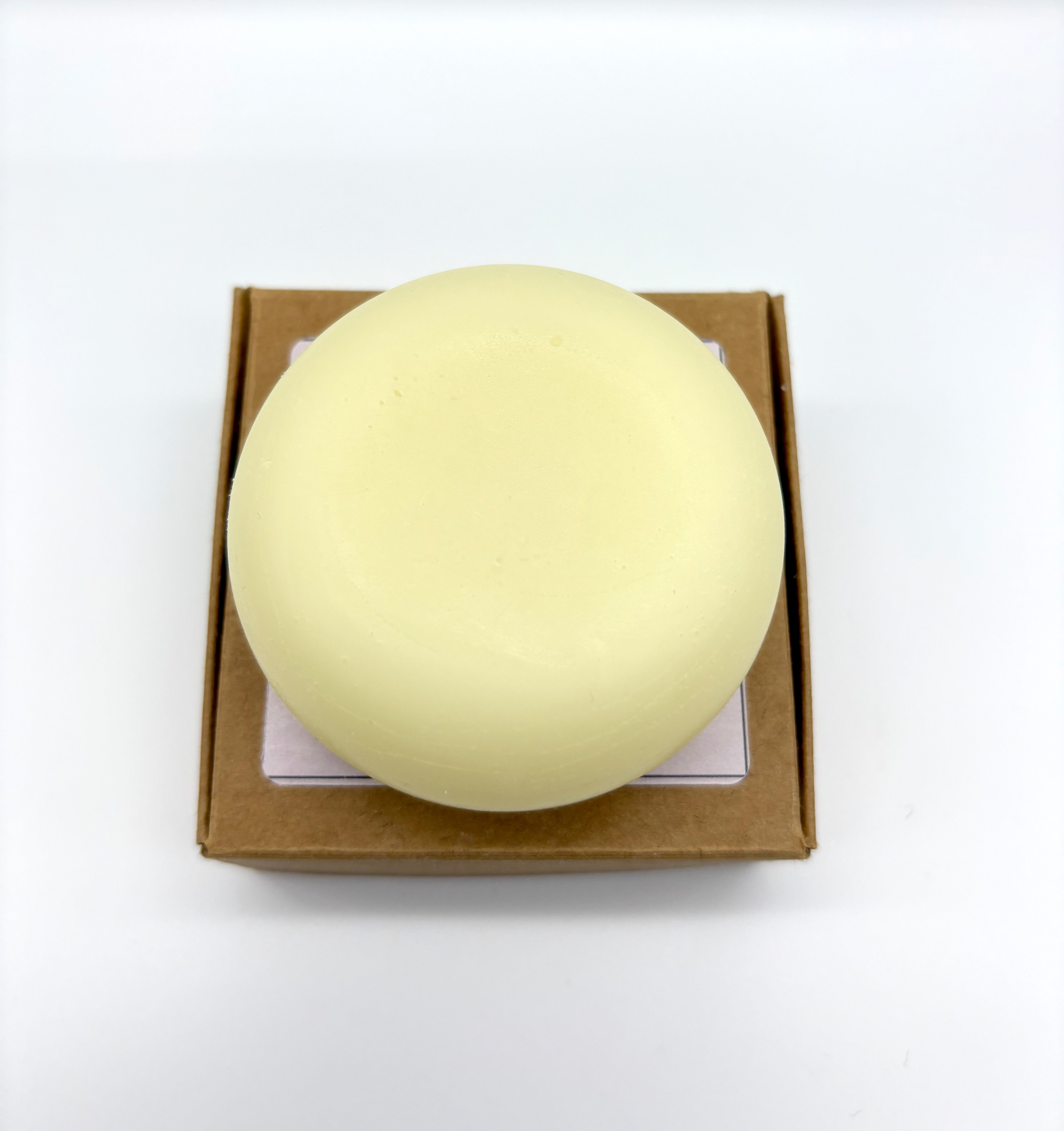 A circular round yellow conditioner bar sat on top of brown box
