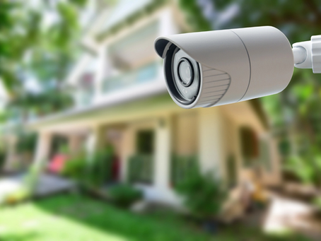 A closeup shot of an outdoor security camera on a residential property. 