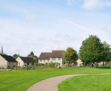 Serene suburban scene with stone houses, brown roofs, and lush gardens