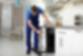Professional serviceman repairing modern oven in kitchen 