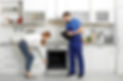 Housewife with repairman near modern oven in kitchen 