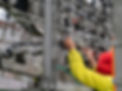 Worker in bright yellow and red uniform adjusts machinery in an industrial setting