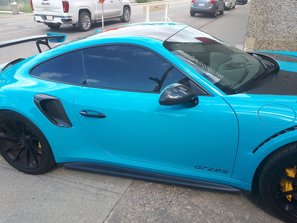 A vibrant turquoise sports car, a GT2 RS, parked on the street
