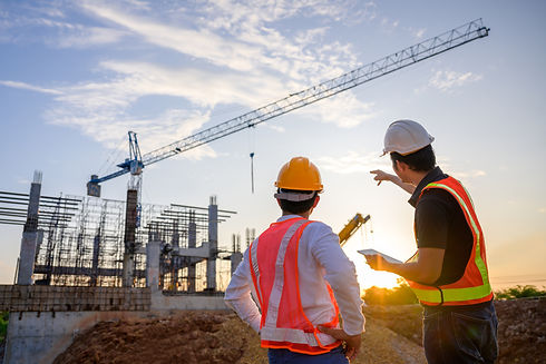 A team of construction engineers talks to managers and construction workers