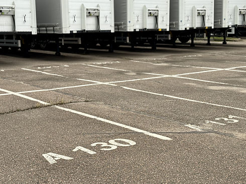 Row of white truck trailers parked in an industrial lot