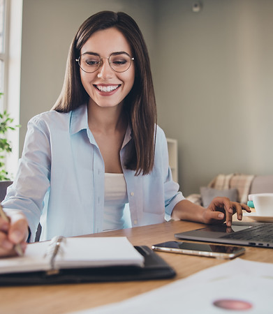 Smiling woman in glasses works from home