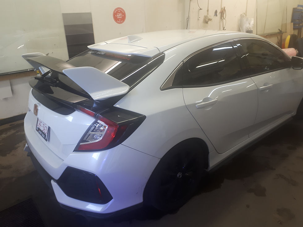 White sports car with a large rear spoiler and tinted windows