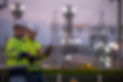 Professional engineers using a digital tablet at a petrochemical refinery