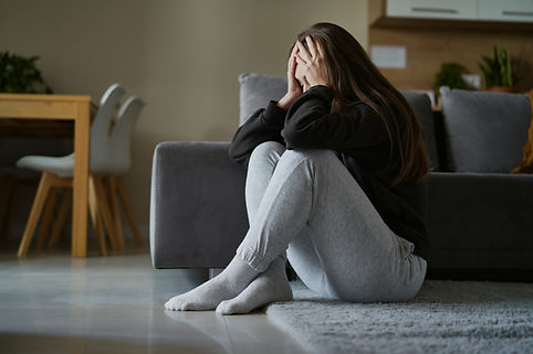 broken woman sitting at the floor in living room