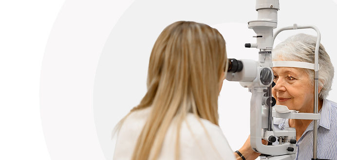 Eye doctor examining an elderly patient's eyes with a slit lamp microscope