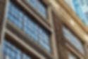 Section of a warehouse style building with a high rise behind