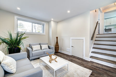 Modern living room with two gray sofas, white coffee table, and decorative plant