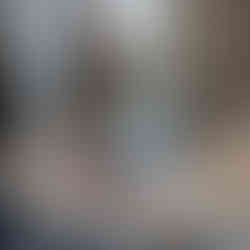 A man in a baseball cap sitting at a table with a computer.