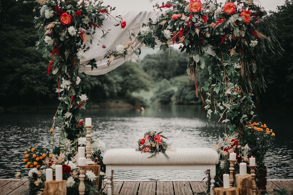 Arco de boda floral en el embarcadero de un lago.