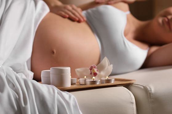 Young pregnant woman having massage in spa salon.jpg