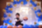 Blue white and gold balloon arch with neon backdrop for a first birthday