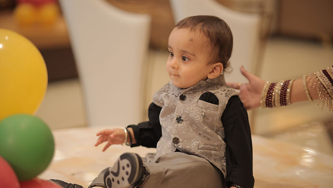 Baby with balloons at a first birthday party