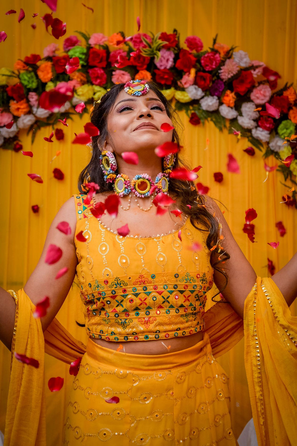 Bride during a haldi ceremony with flower petals