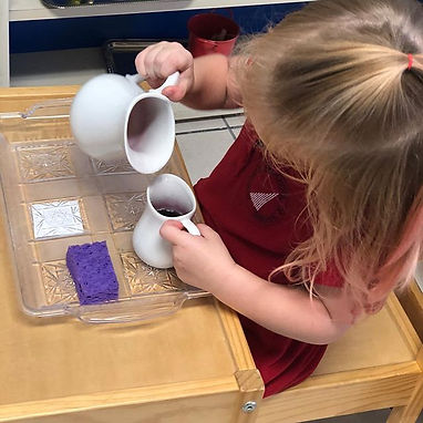 Kid pouring liquid in a cup