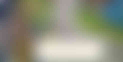 A screenshot of Coral Island where the player character is meeting Pablo. He stands with a gloved hand in his work apron's pocket and a bright smile on his face. He's got an intricate tattoo on his right arm. He says: "You're surprisingly cute!"