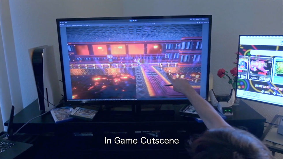 An in-game screenshot from The Remake of the End of the Greatest RPG of All Time. An FMV shot with a developer, visible only from the top of their head and one arm, points at a video of the game playing on a TV in front of them at a home desk with a PS5 and a handful of games atop it. Text at the bottom says "In Game Cutscene."