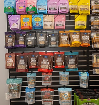Healthy and nutritious retail dog foods, snacks and treats on a wall at The Dog Stop.