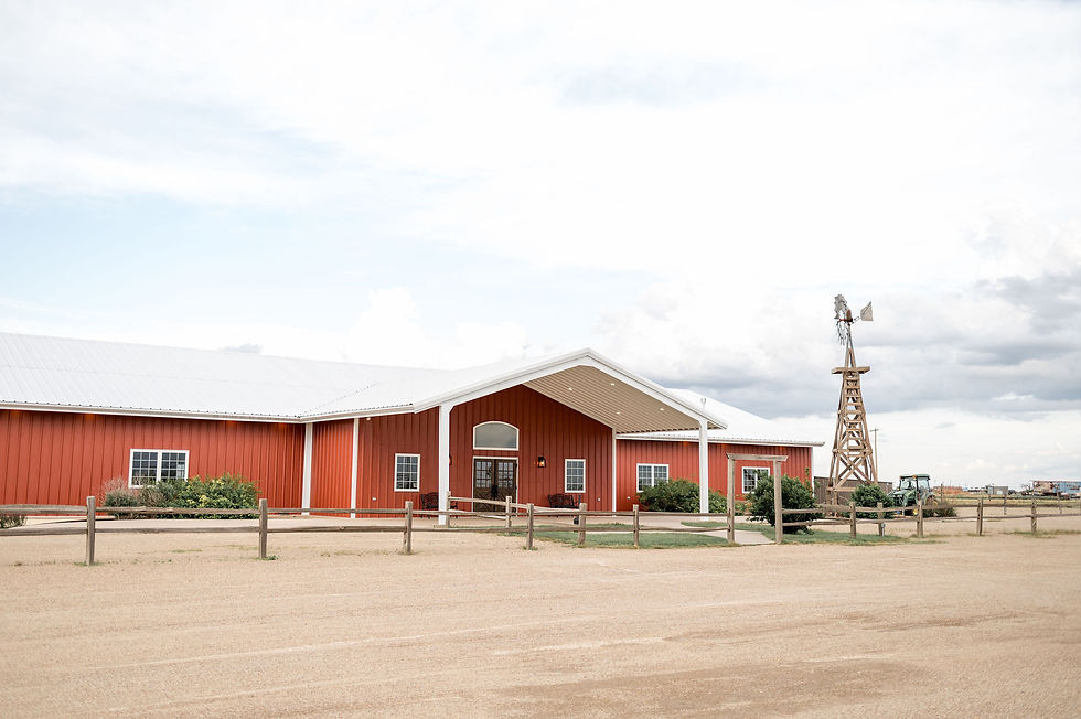 Stunning Amarillo party barn in Texas that is rustic feel, red metal wit white roof, large rustic windmill out front with beautiful landscaping and west texas skies. Indoor and outdoor wedding ceremony sites, helpful with wedding planning