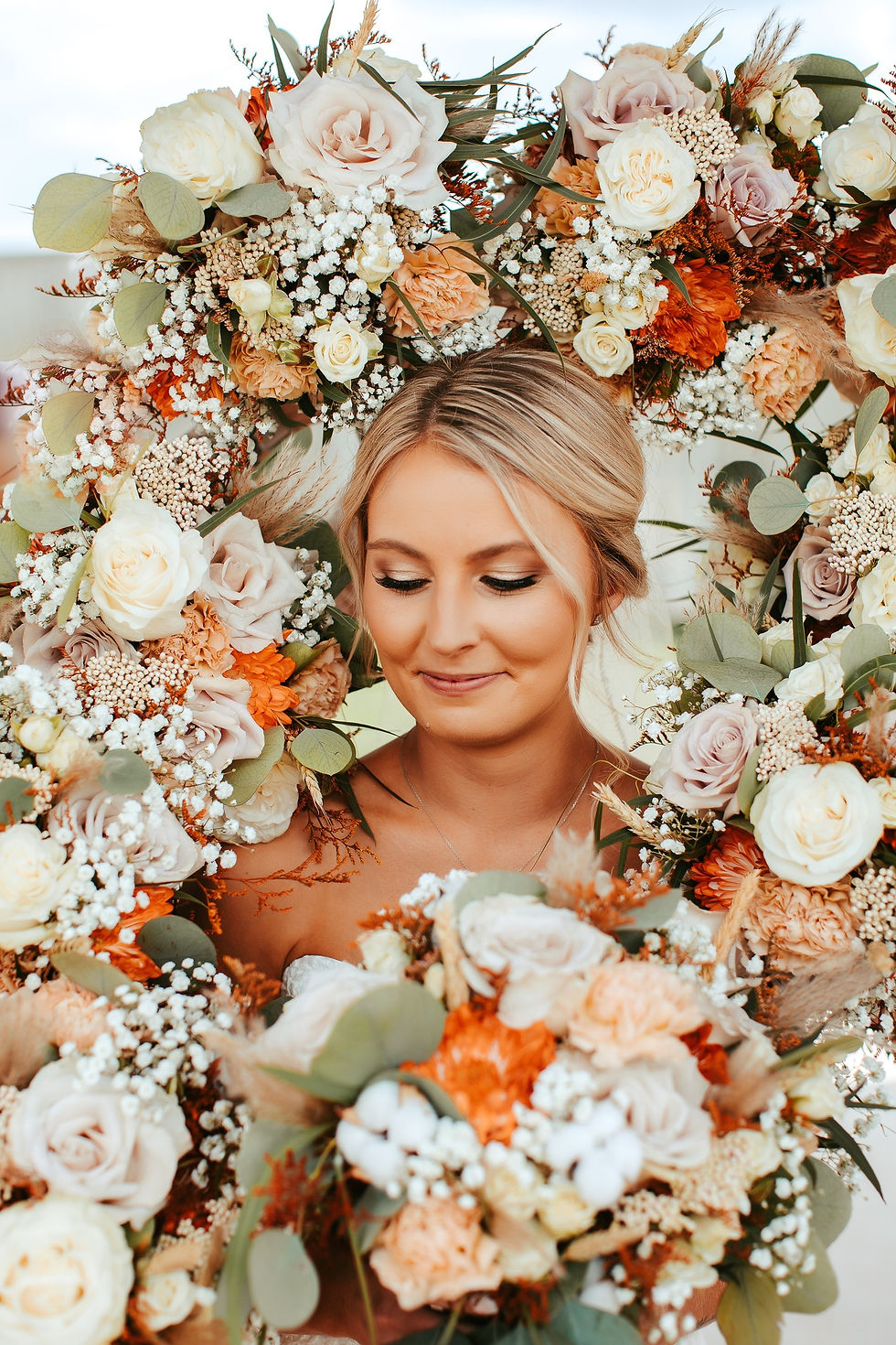 Summer wedding with bride surrounded by fresh florals in white, off white, burnt orange, peach, and sage green, cultivating kindness was the florist, amarillo texas wedding venue