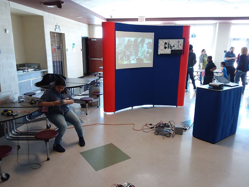 The ScBots display and video. One of the students is setting up a controller.