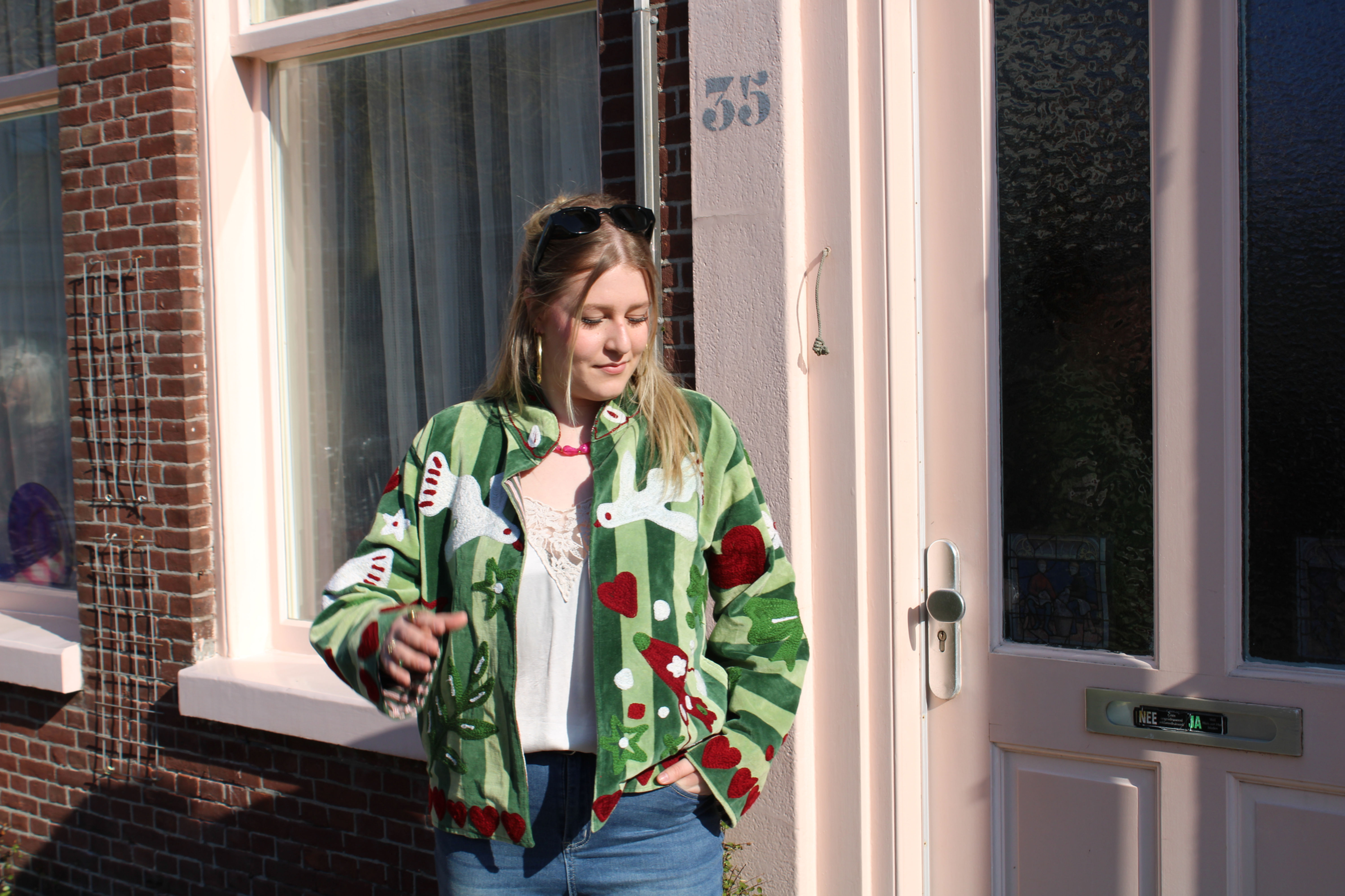 Vrouw draagt PUCK groen geborduurd damesjasje met losse pasvorm en zachte voering