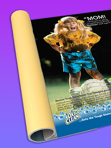 Picture of magazine with OxiClean ad with a dirty soccer playing child, on purple and pink background