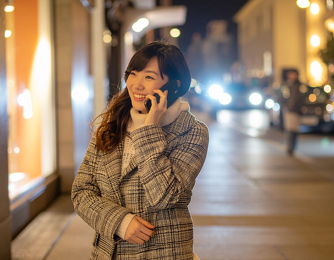 Firefly_電話している 日本人 夜 女性 嬉しそう 帰り道 通話している 被写体は引きで全身が写っている 全身 夜の街を歩きながら通話している コートを着ている 冬 .jpg