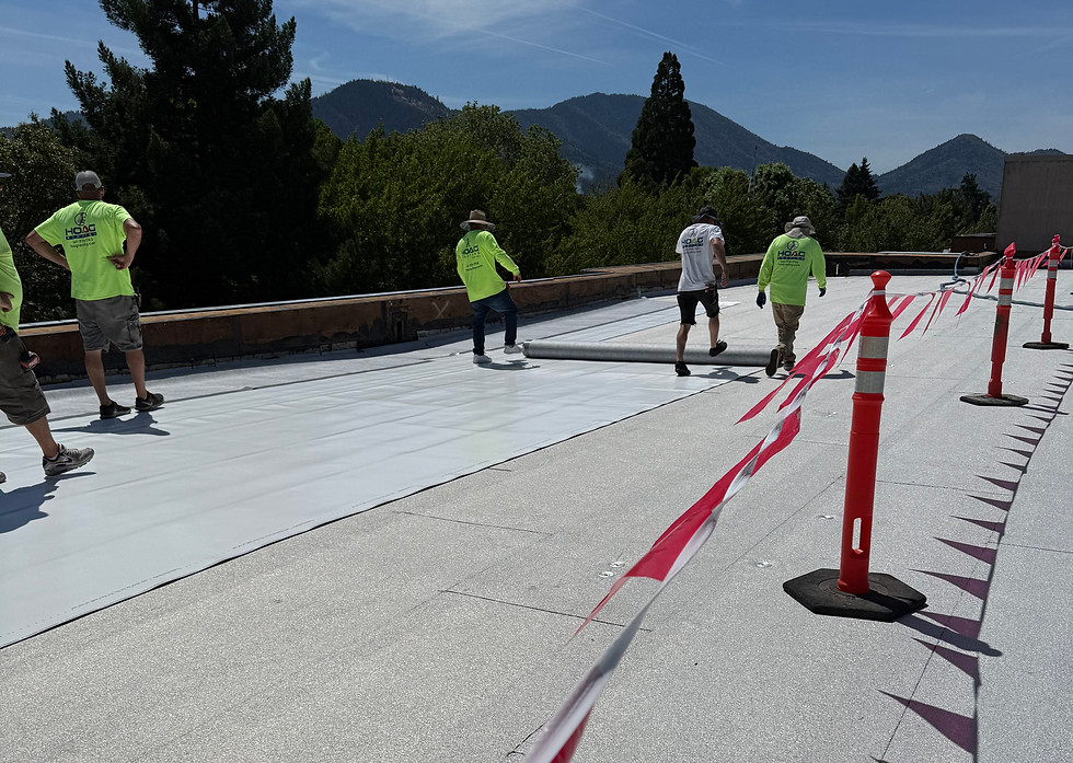 Photo of Hoag roofing crew members rolling out roof underlayment