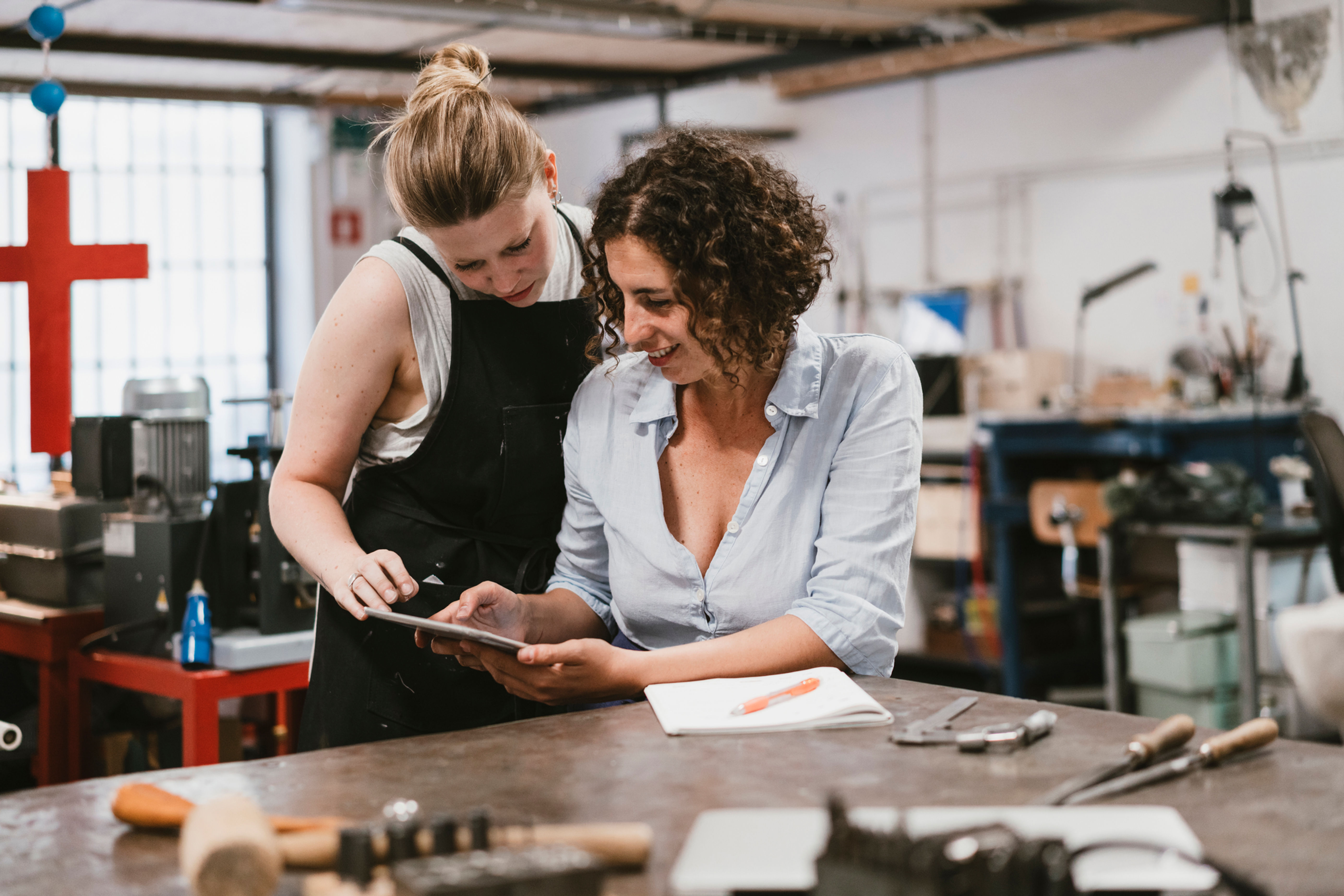 Two women collaborating on a project in a workspace