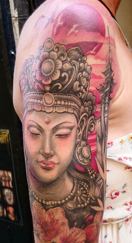 Recouvrement d’un tatouage pré existant, aussi appelé cover ou cover up, par un bouddha femme réaliste en couleur et noir et blanc. 