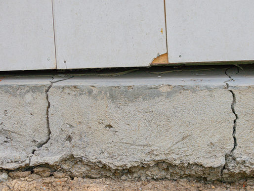 Cracked concrete foundation wall requiring structural inspection during a home purchase.