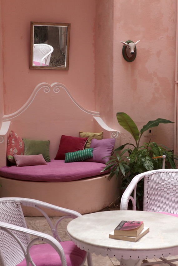 courtyard patio canne furtniture coffee table reading book cow heads french colonial quarters design interiors Holy Chic Homes La Vie en Rose Pondicherry India agathe lazaro