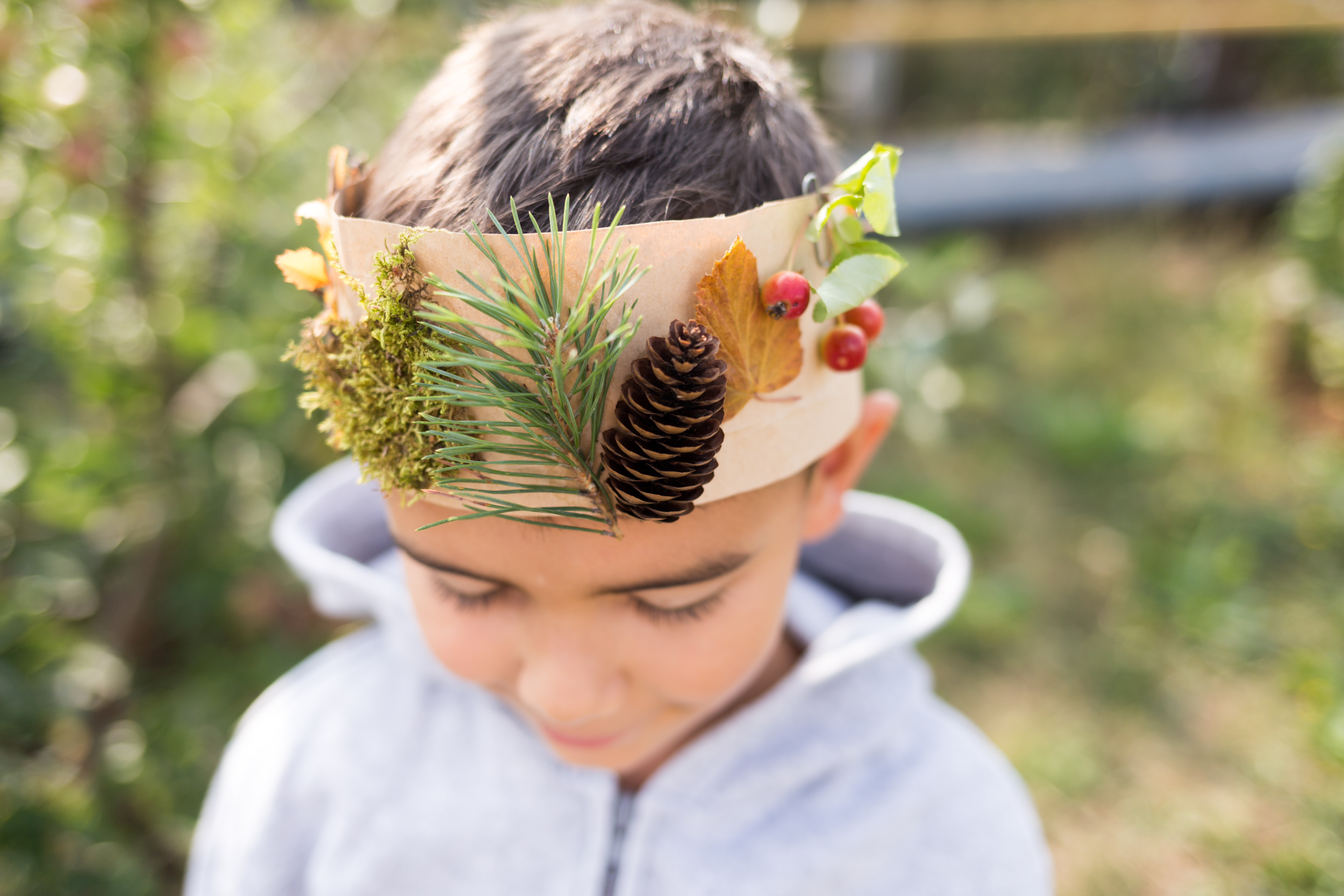 Child wearing a crown made of natural materials during garden club