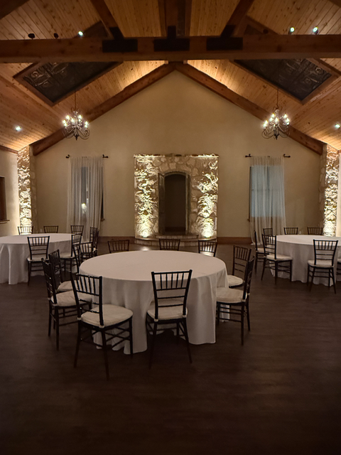 Elegant reception tables arranged with chairs for wedding guests.