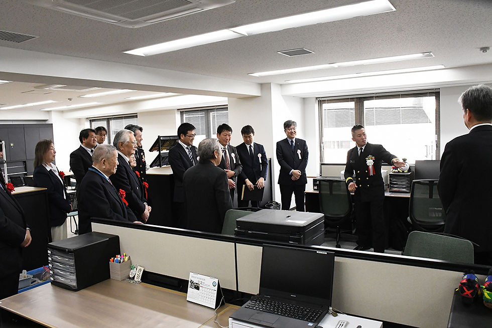 東1尉から事務所の説明を受ける来賓者（2月17日、大阪市中央区難波）