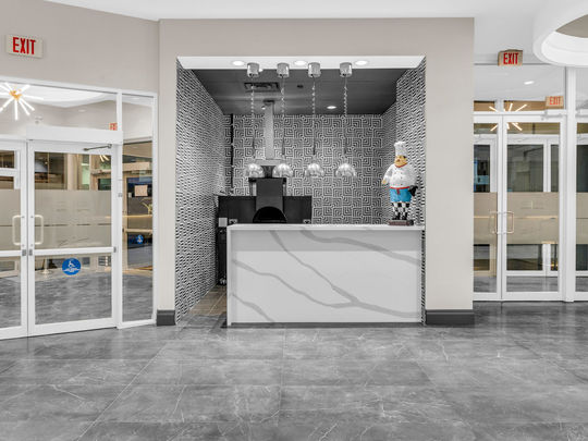 Commercial quartz front counter with geometric wall tiles and pendant lighting by GTA Kitchen Depot Toronto.