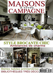 Couverture d'un magazine avec un salon où l'on voit au premier plan de chaise blanche et au fond un canapé blanc avec au milieu une table basse