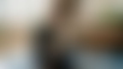 Woman writing gratitude journal in sunny living room